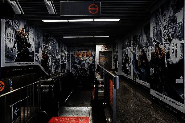 玩家在凤起路地铁站内与《三国杀移动版》角色立牌合影，背景为动态灯箱与游戏台词装饰