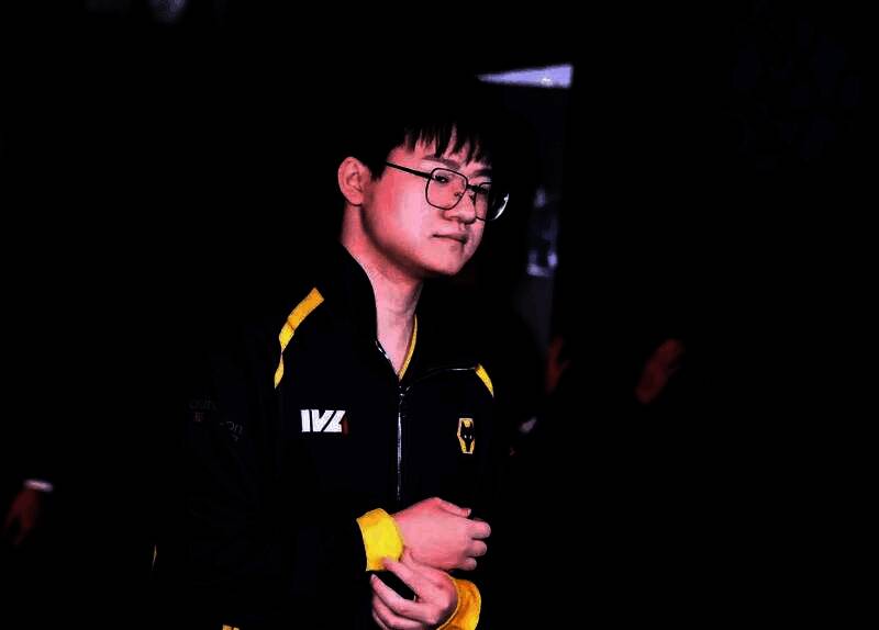 Wolves_Jelly专注比赛中的特写镜头，眼神坚定，手握鼠标，身后是战队应援灯牌闪烁