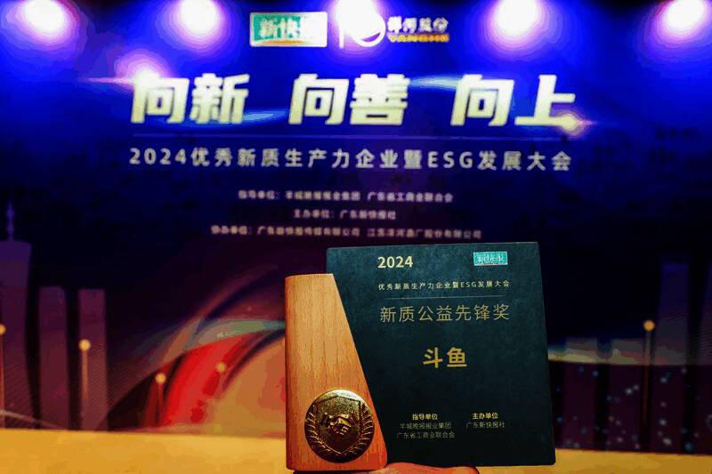 斗鱼荣获‘新质公益先锋奖’现场颁奖画面，背景为大会主题展板，气氛庄重热烈