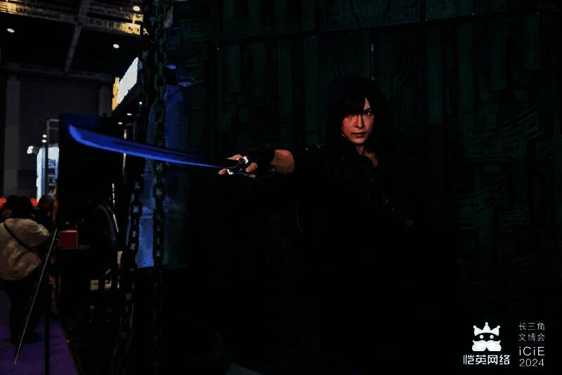 COSER扮演的张起灵与吴邪站在展台中央，周围粉丝兴奋合影，现场氛围热烈