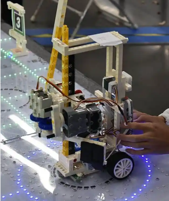 高清示意图：现代化无尘恒温芯片光刻车间内部实景，银灰色金属风道纵横交错，工程师身穿连体白色净化服与面罩，在巨型光刻设备前专注操作，背景可见温湿度实时监测屏显示‘22.3℃/44.8%RH’