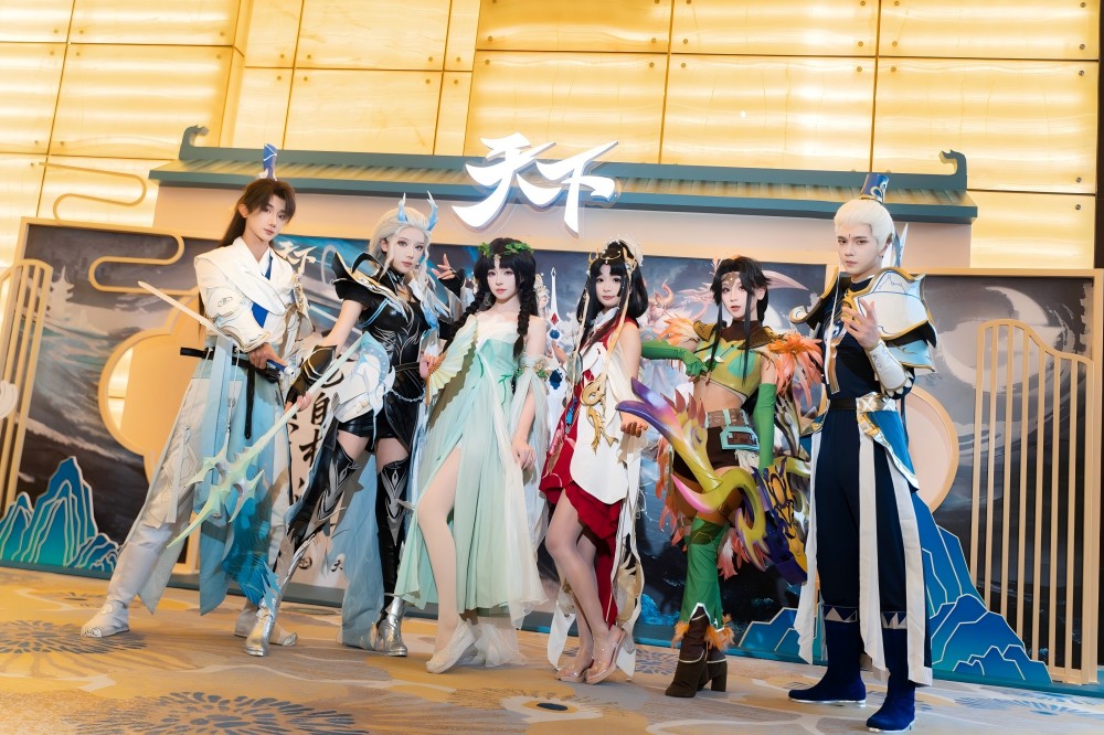 制作人登台演讲特写：主讲人手持‘6000天’纪念徽章，背景大屏滚动播放历代版本经典画面与玩家UGC内容混剪